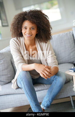 Beuatiful mixed race woman relaxing in canapé Banque D'Images