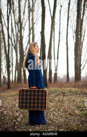 Femme marche en forêt avec vieille valise à la recherche d'un moyen d'aller Banque D'Images