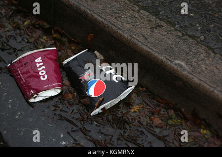 Les tasses de café vides jonchent les rues et sur la route au Royaume-Uni. Banque D'Images