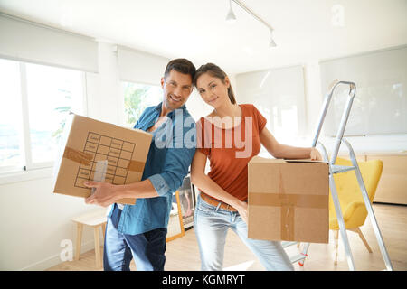 Couple holding cartons dans maison neuve Banque D'Images