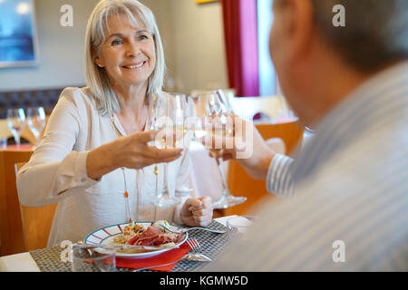 Senior couple having dinner in restaurant, cheering up Banque D'Images