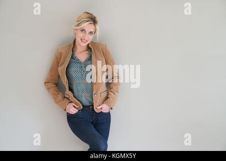 Middle-aged woman standing sur fond gris, isolé Banque D'Images