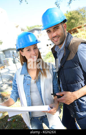 Architectes smiling standing on construction site Banque D'Images