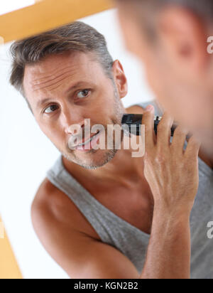 Beau mec en face du miroir de rasage Banque D'Images