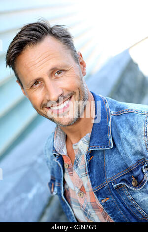 Smiling man standing by bâtiment moderne en ville Banque D'Images