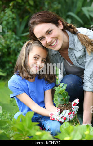 Portrait de petite fille avec la mère dans le jardin intérieur Banque D'Images