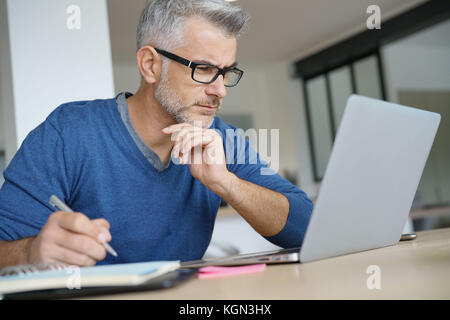 Homme d'âge moyen de travailler à domicile-bureau pour ordinateur portable Banque D'Images