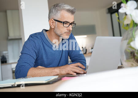 Homme d'âge moyen de travailler à domicile-bureau pour ordinateur portable Banque D'Images