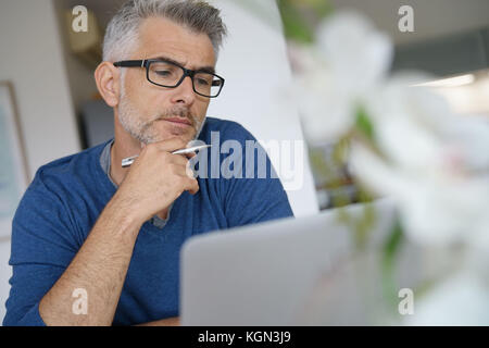 Homme d'âge moyen de travailler à domicile-bureau pour ordinateur portable Banque D'Images