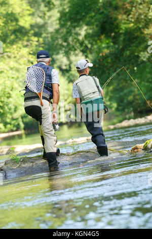 Vue arrière de père et fils voler la pêche en rivière Banque D'Images