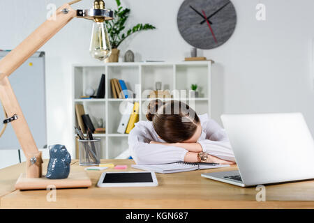 Businesswoman sleeping on desk Banque D'Images