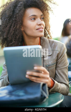 Businesswoman sitting in park, travaillant sur tablette numérique Banque D'Images