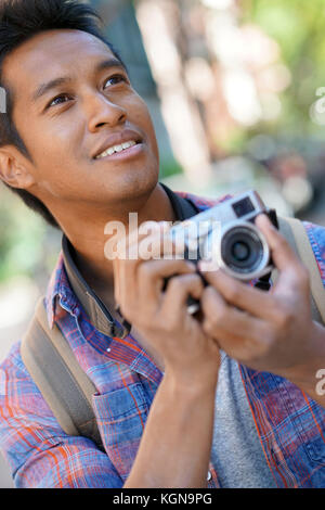 Jeune homme prenant photo dans quartier de New York Banque D'Images