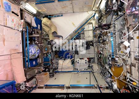 Station spatiale internationale, orbite terrestre. 09 novembre 2017. Les jambes de l'astronaute américain Randy Bresnik de l'expédition 53 sortent alors qu'il manœuvre autour des râteliers d'engins qui bordent la Station spatiale internationale pour le stockage le 9 novembre 2017 en orbite terrestre. Crédit : Planetpix/Alamy Live News Banque D'Images