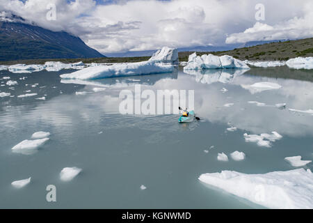 Vue arrière de la personne canoë lagoon contre ciel nuageux, Lake George, Palmer, Alaska Banque D'Images