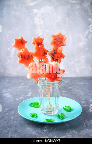 Watermelon en forme d'étoiles sur les brochettes avec les feuilles de menthe est dans un bocal en verre Banque D'Images