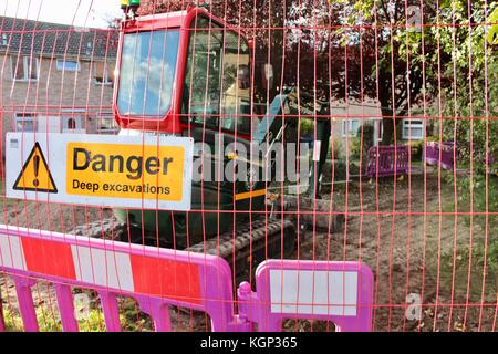 Danger des excavations profondes connexion enclos avec digger rouge Banque D'Images