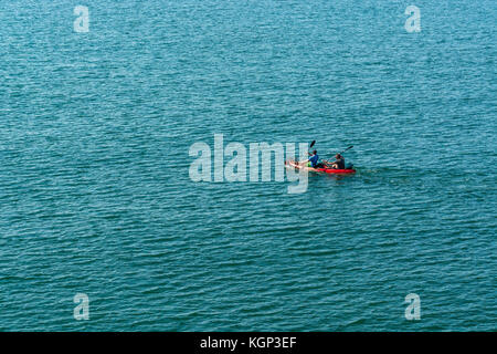 Siège double kayak de mer d'être pagayé en mer par deux canoéistes. Ils sont d'aller à ligne-poisson pour le maquereau dans les eaux peu profondes. Concept isolé. Banque D'Images
