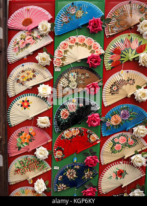 Affichage de coloré flamenco espagnol folding fans entrecoupées de roses rouges et blanches à Cordoue, Espagne Banque D'Images