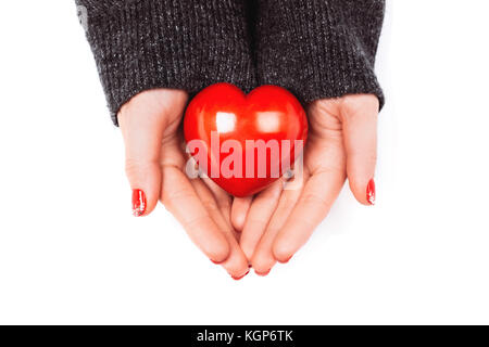 Woman's hands avec belle manucure précis garder soigneusement cœur rouge. concept de donner de l'aide pour eux, qui a besoin. Banque D'Images