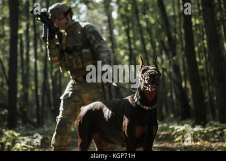 Image de joueur d'airsoft avec mitraillette et chien Banque D'Images