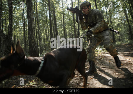 Image de joueur d'airsoft avec doberman et mitraillette Banque D'Images