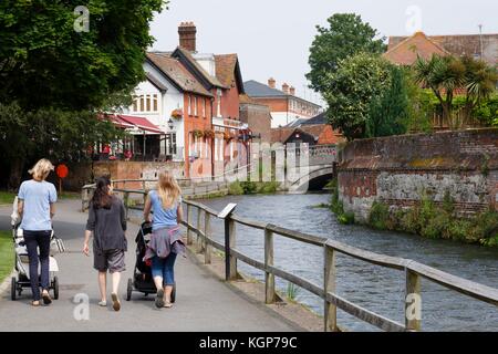 Les femmes avec poussettes de marche à côté de la rivière Itchen Winchester, dans le Hampshire, au Royaume-Uni Banque D'Images