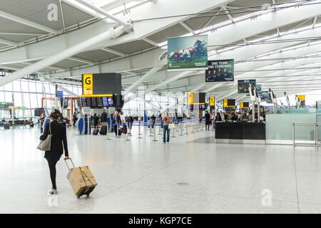 Une passagère arrive pour arrivée à l'hall de départ de l'aérogare 5, l'aéroport de Heathrow Banque D'Images