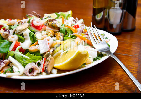 Une salade de fruits de mer avec rucola et jus de citron Banque D'Images