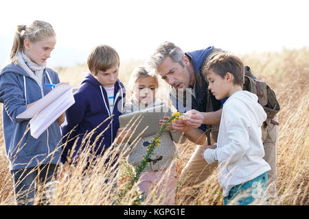 En enseignant les enfants à la campagne pour découvrir les plantes et les fleurs Banque D'Images