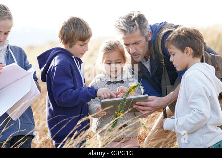 En enseignant les enfants à la campagne pour découvrir les plantes et les fleurs Banque D'Images