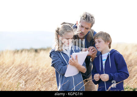 En enseignant les enfants à la campagne pour découvrir les plantes et les fleurs Banque D'Images