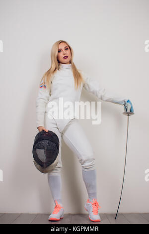 Femme portant tenue d'escrime pratiquant avec épée contre fille vignette gris Banque D'Images