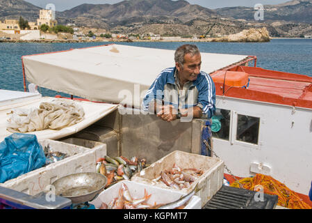 La Grèce, Îles de la mer Égée, l'île de Karpathos, un pêcheur La pêche dans ses charges Pigadia Banque D'Images