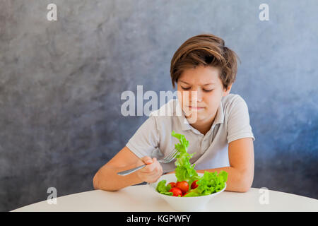 Cute teen boy n'aimez eating salad Banque D'Images