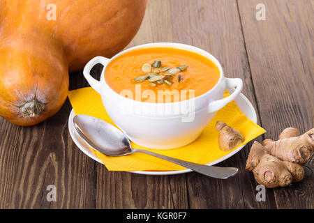 Soupe de crème de potiron au gingembre sur un fond de bois Banque D'Images