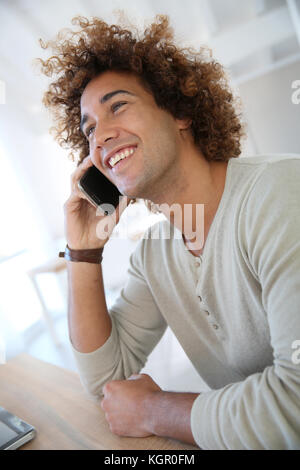 Smiling man talking on mobile phone Banque D'Images