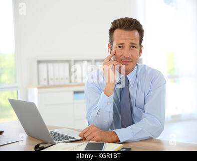 Handsome businessman working on laptop in office Banque D'Images