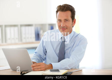 Handsome businessman working on laptop in office Banque D'Images