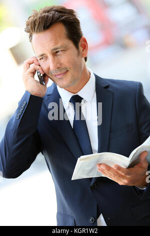 En ville attractive businessman talking on mobile phone Banque D'Images