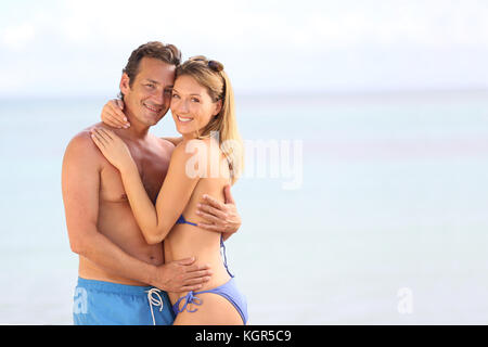 Couple aimant en maillot embrassant sur la plage Banque D'Images