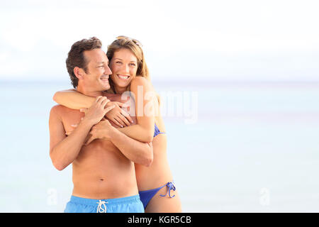 Couple aimant en maillot embrassant sur la plage Banque D'Images