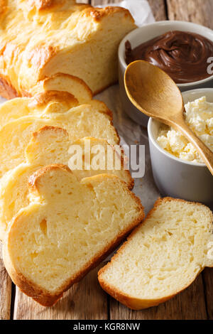 Brioche fraîchement pain et fromage à la crème, crème au chocolat macro sur la table verticale. Banque D'Images
