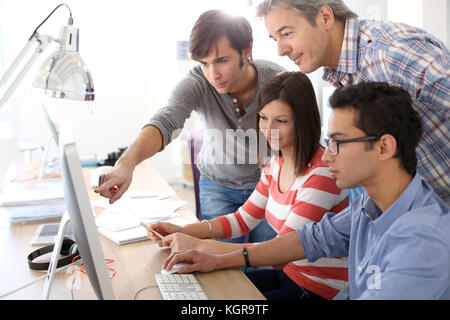 Avec les élèves de l'enseignant sur le bureau de travail Banque D'Images