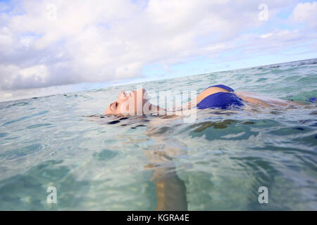 Closeup of woman floating in lagoon Banque D'Images