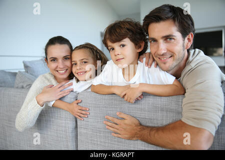 Famille de quatre heureux de vous détendre dans un canapé Banque D'Images