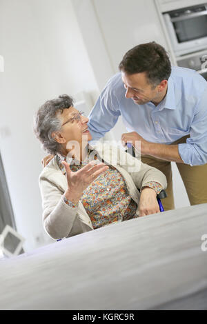 Homecarer soutenir femme âgée à la maison Banque D'Images