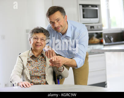Homecarer soutenir femme âgée à la maison Banque D'Images