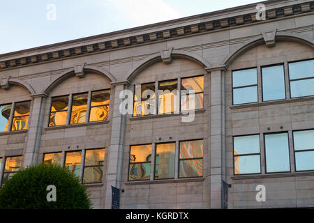 Baigné de construction en fin d'après-midi, la lumière est réfléchie avec une distorsion dans les fenêtres d'un autre bâtiment. Banque D'Images