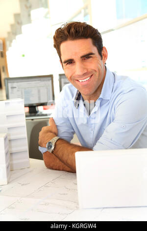 Smiling architect sitting in office Banque D'Images